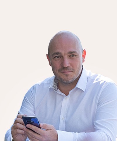 Ian Heslop in a white shirt, holding his phone